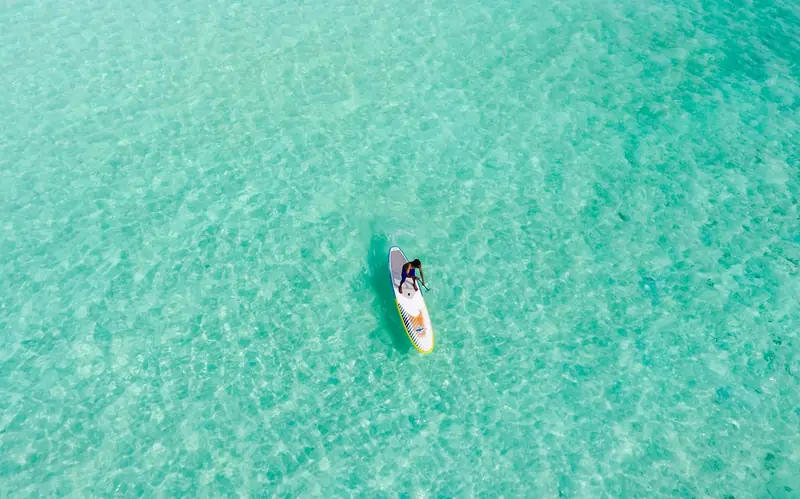 Paddle board na průzračném tyrkysovém moři, pohled shora