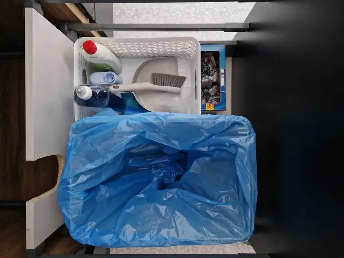 Koš a čisticí prostředky pod dřezem