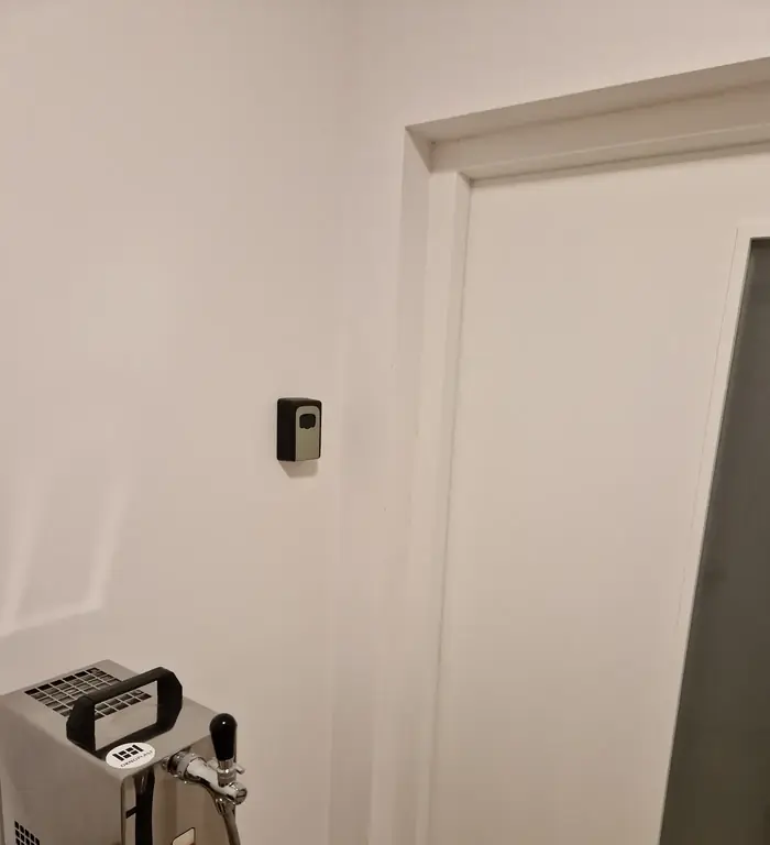 Trezůrek s klíčem na zdi před dveřmi apartmánu