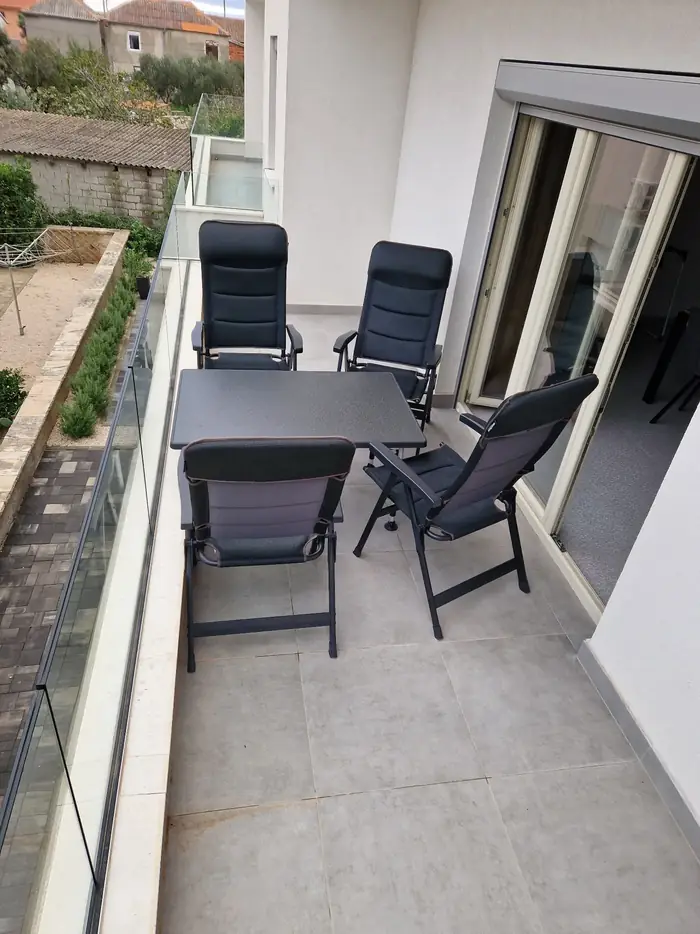 Balkon apartmánu se stolem a polohovacími křesly