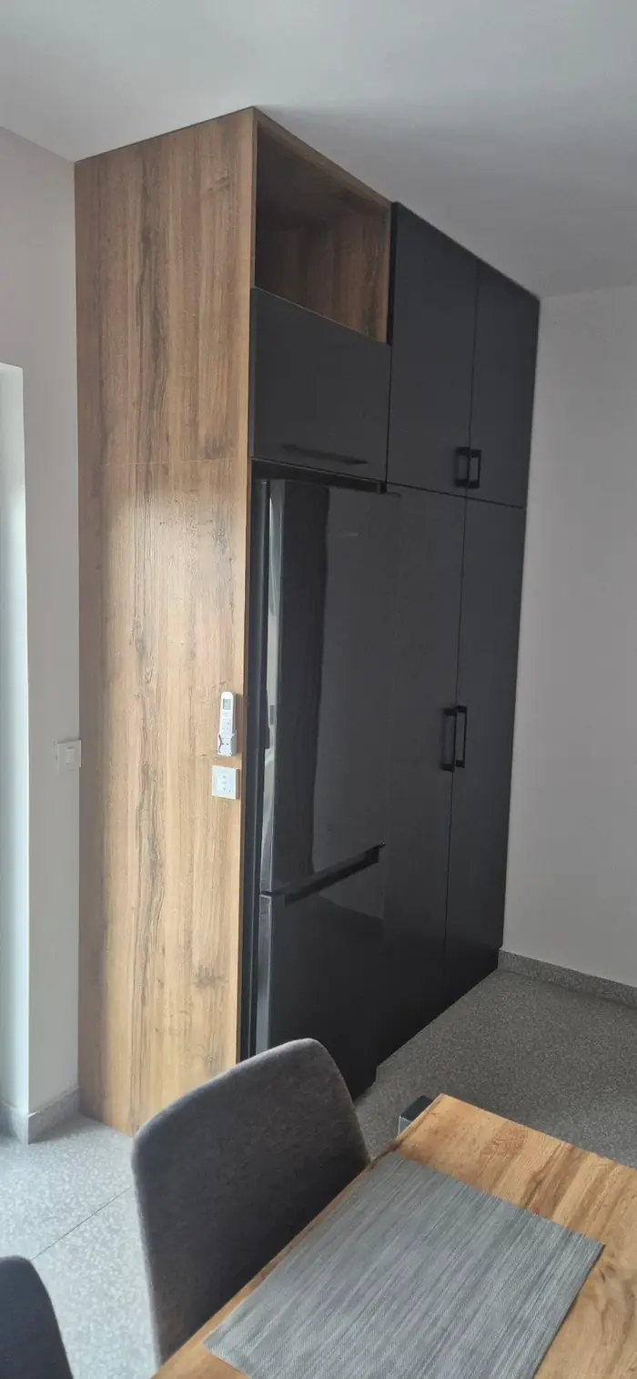 Vysoká skříň s povlečením vedle lednice