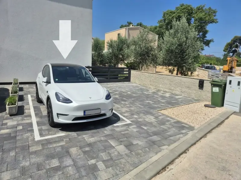 Vyhrazené parkovací místo před domem, šipka ukazuje kam
